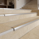 Bullnose stair nosing with beige anti-slip insert fitted to cream limestone-effect tiled hotel steps