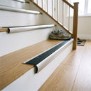 Bullnose stair nosing with black anti-slip insert fitted to light oak stair treads in a UK hallway