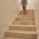 Tile-in aluminium step edging in Champagne — installed on tiled UK staircase with person using the stairs