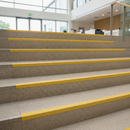 High-visibility yellow GRP stair nosing on public building steps — DDA compliant step edge marking