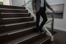 Anti-slip aluminium stair nosing with Black PVC insert — installed on UK staircase with person using the stairs