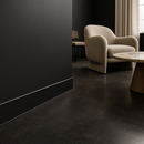 Black flexible skirting board trim in luxury UK interior with dark concrete flooring