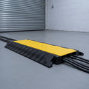 3 channel cable protection ramp in use on a warehouse loading bay floor with cables running through its channels