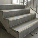 Aluminium tile-in stair nosing with a canvas cream anti-slip PVC insert set into the edge of grey tiled stairs