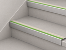 Canvas cream and green insert stair nosings fitted to two pale tiled steps against a white stringer wall