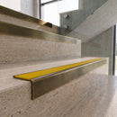 Antique Brass carborundum insert stair nosing with canary yellow ridged PVC insert fitted to travertine steps