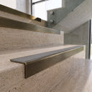 Antique Brass carborundum insert stair nosing with fog grey ridged PVC insert fitted to travertine steps