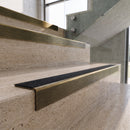 Antique Brass carborundum insert stair nosing with obsidian CarbiGrip insert fitted to travertine steps