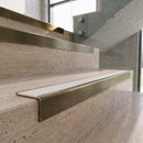 Antique Brass carborundum insert stair nosing with snow white ridged PVC insert fitted to travertine steps