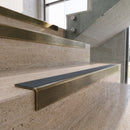 Antique Brass carborundum insert stair nosing with storm grey ridged PVC insert fitted to travertine steps