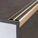 Close-up of champagne anodised 36x20mm aluminium stair nosing with two black anti-slip rubber inserts on a step edge