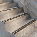 Champagne anodised nosings edging light concrete stairs, matched to the champagne handrail and wall rails