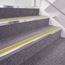 Bright Polished double insert chevron stair nosing, 40mm riser with Yellow inserts, fitted on carpeted stairs