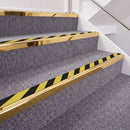 Mirrorflect Gold double insert chevron stair nosing, 40mm riser with Hazard black and yellow inserts, fitted on carpeted stairs