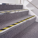 Mirrorflect Silver double insert chevron stair nosing, 40mm riser with Hazard black and yellow inserts, fitted on carpeted stairs