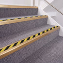 Satin Bronze double insert chevron stair nosing, 40mm riser with Hazard black and yellow inserts, fitted on carpeted stairs