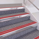 Bright Polished double insert chevron stair nosing, 60mm riser with Red inserts, fitted on carpeted stairs