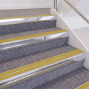 Bright Polished double insert chevron stair nosing, 60mm riser with Yellow inserts, fitted on carpeted stairs