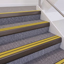 Dark Bronze double insert chevron stair nosing, 60mm riser with Yellow inserts, fitted on carpeted stairs