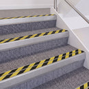 Mill Finish double insert chevron stair nosing, 60mm riser with Hazard black and yellow inserts, fitted on carpeted stairs