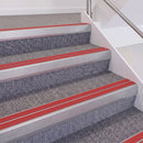 Mill Finish double insert chevron stair nosing, 60mm riser with Red inserts, fitted on carpeted stairs