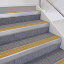 Mill Finish double insert chevron stair nosing, 60mm riser with Yellow inserts, fitted on carpeted stairs