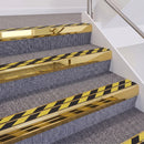 Mirrorflect Gold double insert chevron stair nosing, 60mm riser with Hazard black and yellow inserts, fitted on carpeted stairs