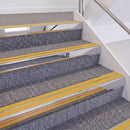 Mirrorflect Silver double insert chevron stair nosing, 60mm riser with Yellow inserts, fitted on carpeted stairs