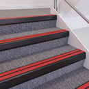 Satin Black double insert chevron stair nosing, 60mm riser with Red inserts, fitted on carpeted stairs