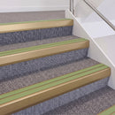 Satin Bronze double insert chevron stair nosing, 60mm riser with Apple Green inserts, fitted on carpeted stairs