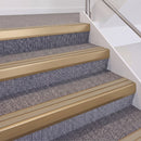 Satin Bronze double insert chevron stair nosing, 60mm riser with Beige inserts, fitted on carpeted stairs
