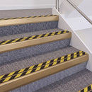Satin Bronze double insert chevron stair nosing, 60mm riser with Hazard black and yellow inserts, fitted on carpeted stairs