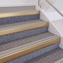 Satin Bronze double insert chevron stair nosing, 60mm riser with Polar Grey inserts, fitted on carpeted stairs