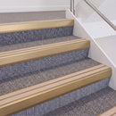Satin Bronze double insert chevron stair nosing, 60mm riser with Sahara inserts, fitted on carpeted stairs