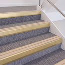 Satin Gold double insert chevron stair nosing, 60mm riser with Sahara inserts, fitted on carpeted stairs