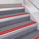 Satin Silver double insert chevron stair nosing, 60mm riser with Red inserts, fitted on carpeted stairs