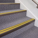 Dark Bronze double insert chevron stair nosing, 70mm riser with Yellow inserts, fitted on carpeted stairs
