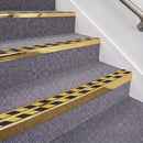 Mirrorflect Gold double insert chevron stair nosing, 70mm riser with Hazard black and yellow inserts, fitted on carpeted stairs
