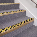 Satin Bronze double insert chevron stair nosing, 70mm riser with Hazard black and yellow inserts, fitted on carpeted stairs