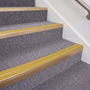 Satin Bronze double insert chevron stair nosing, 70mm riser with Yellow inserts, fitted on carpeted stairs