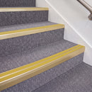 Satin Gold double insert chevron stair nosing, 70mm riser with Yellow inserts, fitted on carpeted stairs
