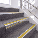 Bright Polished single insert chevron stair nosing, 65mm riser with Yellow insert, fitted on carpeted stairs