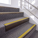 Dark Bronze single insert chevron stair nosing, 65mm riser with Yellow insert, fitted on carpeted stairs