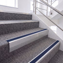 Mill Finish single insert chevron stair nosing, 65mm riser with Dark Blue insert, fitted on carpeted stairs