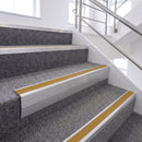 Mill Finish single insert chevron stair nosing, 65mm riser with Yellow insert, fitted on carpeted stairs