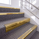 Mirrorflect Gold single insert chevron stair nosing, 65mm riser with Beige insert, fitted on carpeted stairs