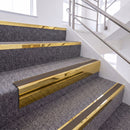 Mirrorflect Gold single insert chevron stair nosing, 65mm riser with Brown insert, fitted on carpeted stairs