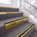 Mirrorflect Gold single insert chevron stair nosing, 65mm riser with Dark Green insert, fitted on carpeted stairs