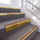 Mirrorflect Gold single insert chevron stair nosing, 65mm riser with Mid Brown insert, fitted on carpeted stairs