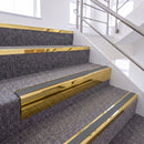 Mirrorflect Gold single insert chevron stair nosing, 65mm riser with Mid Grey insert, fitted on carpeted stairs